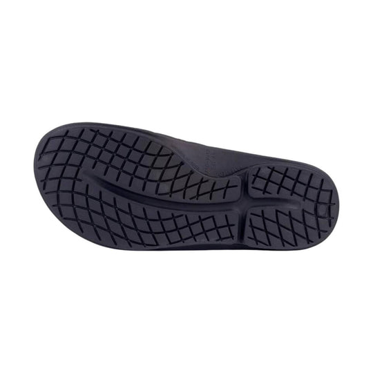 Black rubber slide sandal outsole with a textured tread pattern, shown from below