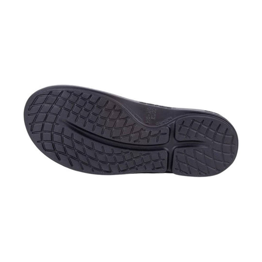 Black shoe outsole with textured tread pattern and molded grooves