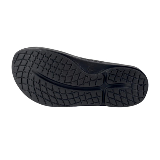 Black sandal outsole with a wavy tread pattern and segmented rubber traction zones