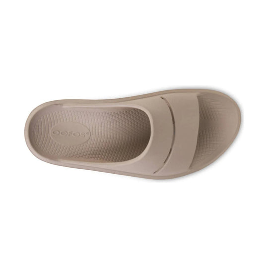 Beige slide sandal sole with textured tread and embossed Oofos logo