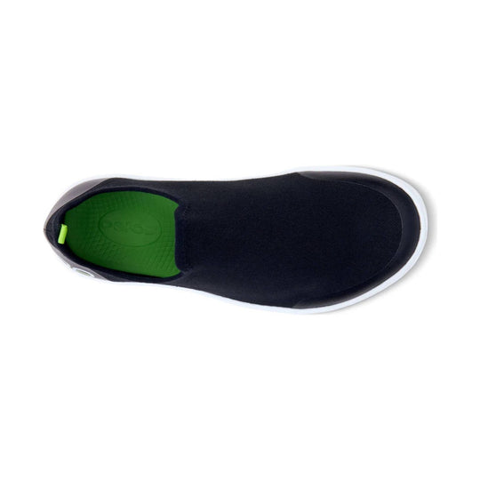 Black slip-on shoe with white sole and green insole, shown from above