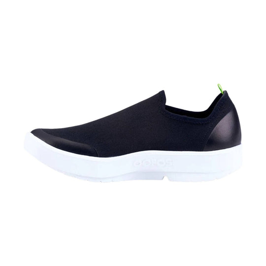 Black slip-on sneaker with a white platform sole and green heel pull tab