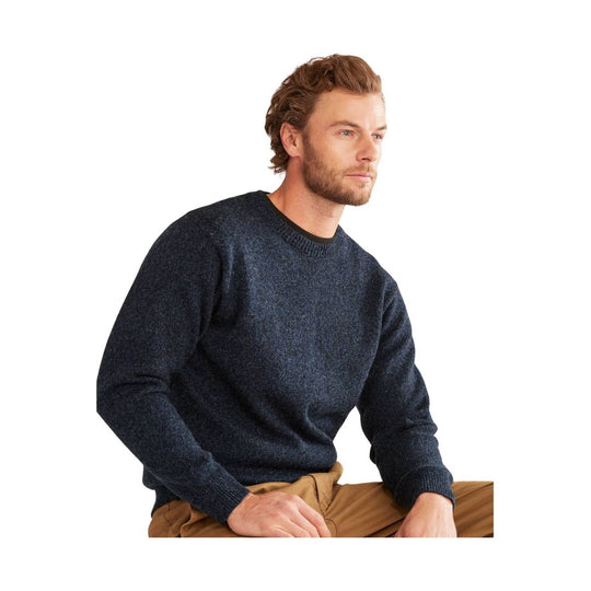 Dark heathered crewneck sweater worn with tan pants, shown in side profile