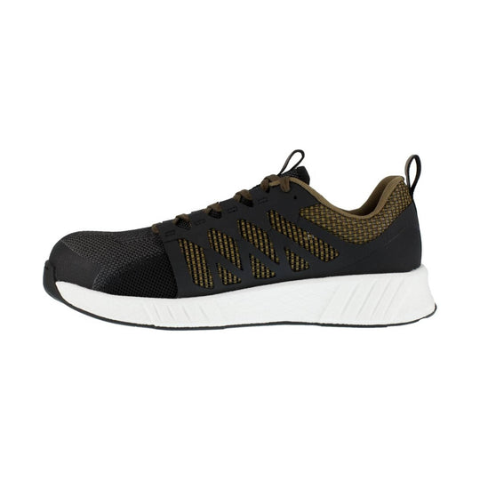 Black athletic work shoe with tan mesh panels, side cutouts, and a thick white sole