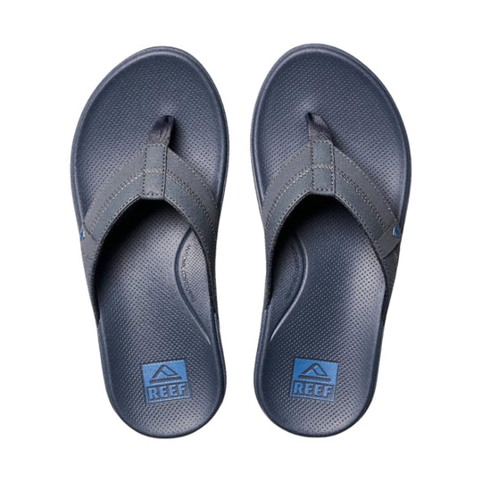 Pair of dark gray flip-flops with textured footbeds and blue REEF logos