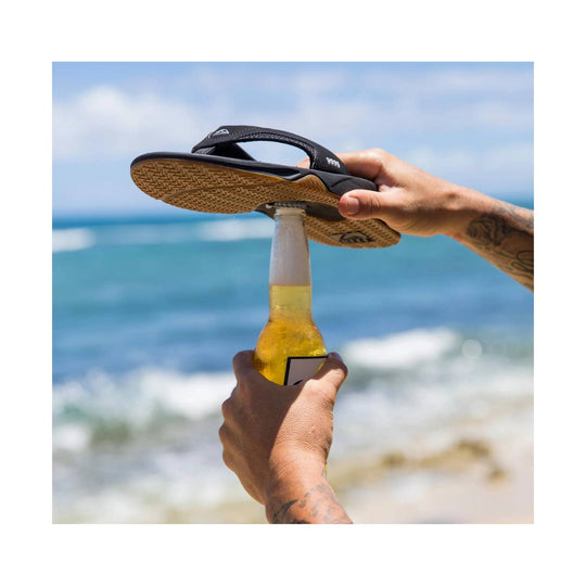 Black thong sandal balanced on a bottle over the ocean