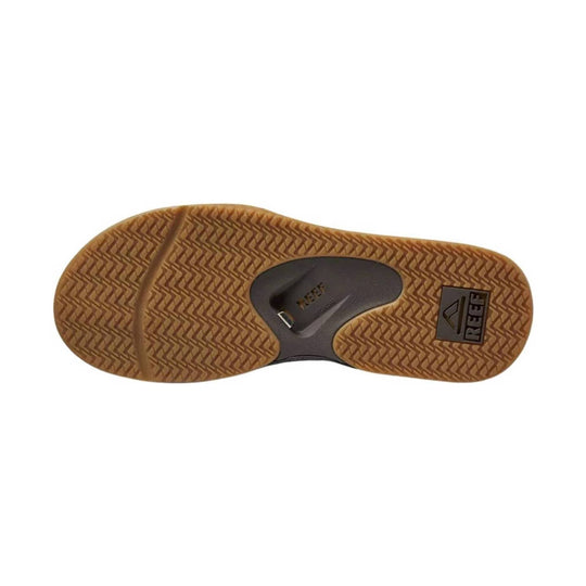 Tan rubber sandal outsole with herringbone tread and visible REEF logo