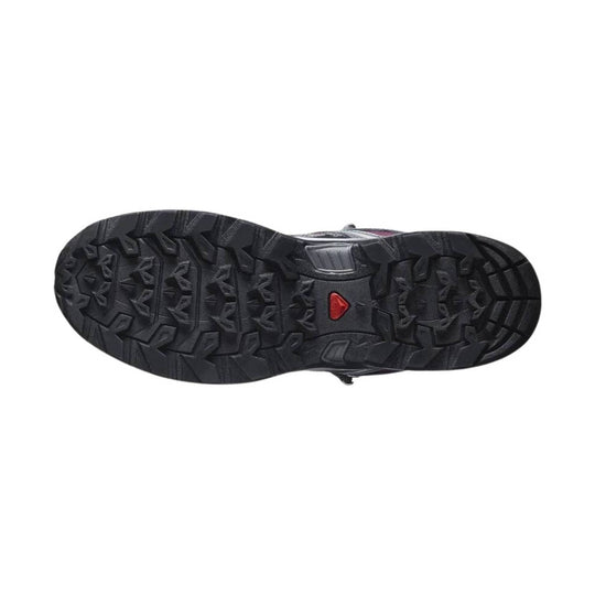 Black hiking boot outsole with deep lug tread and a red logo insert