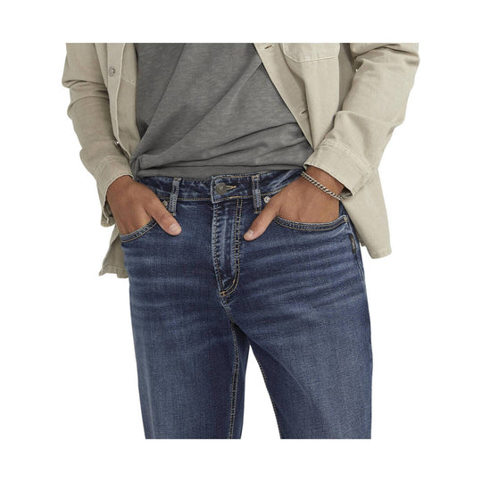 Dark wash straight-leg jeans worn with hands in front pockets