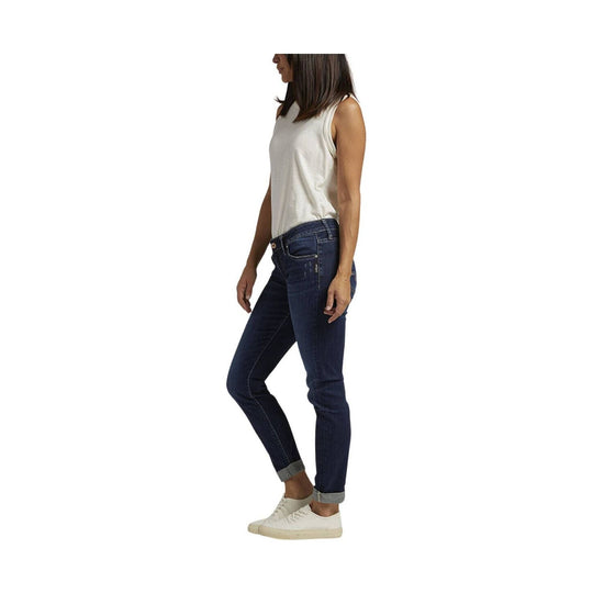 Woman wearing dark wash slim-leg jeans, a white sleeveless top, and white sneakers in side view