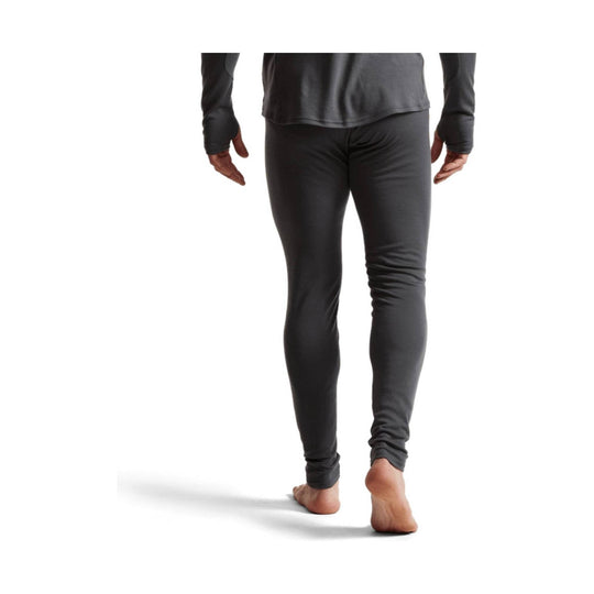 Dark gray fitted thermal base layer pants worn by a model, rear view