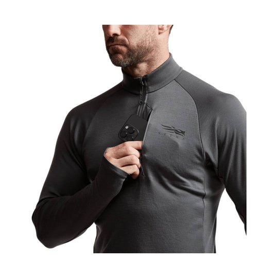 Dark gray long-sleeve quarter-zip base layer with chest logo, shown on a model