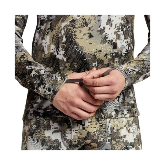 Long-sleeve camo base layer top with thumb holes, shown from chest to hips