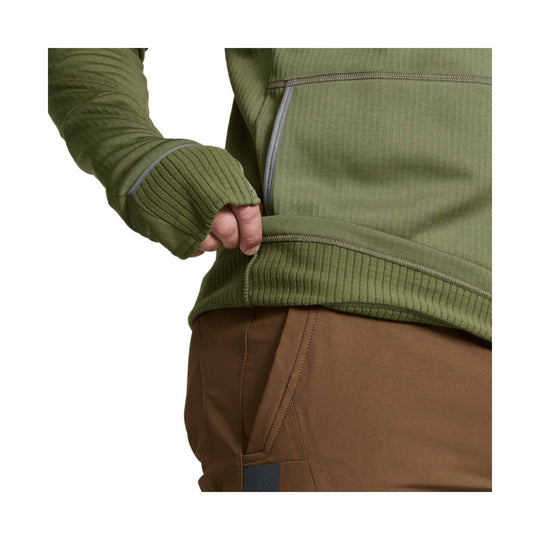 Olive performance hoodie with ribbed panels, thumbhole cuffs, and brown pants