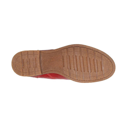 Brown lugged outsole of a red shoe viewed from below