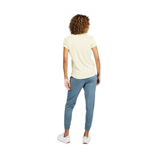 Cream short-sleeve V-neck tee worn with blue jogger pants, shown from the back