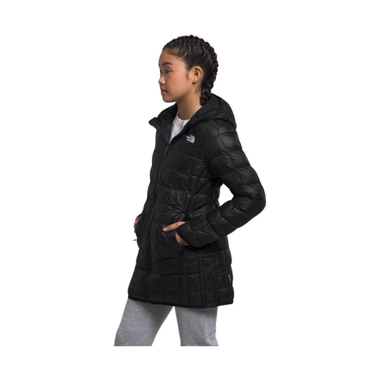 Black quilted hooded girls' winter coat with zip front and hand pockets, shown in side profile