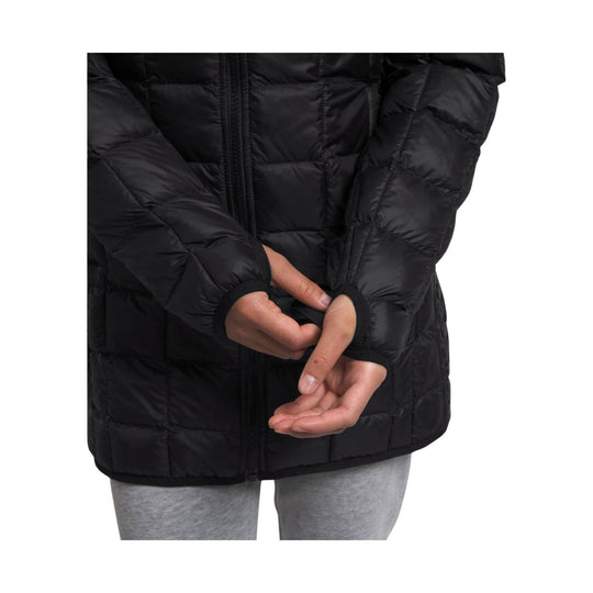 Black quilted hooded puffer parka with front zipper and ribbed cuffs, shown on a model
