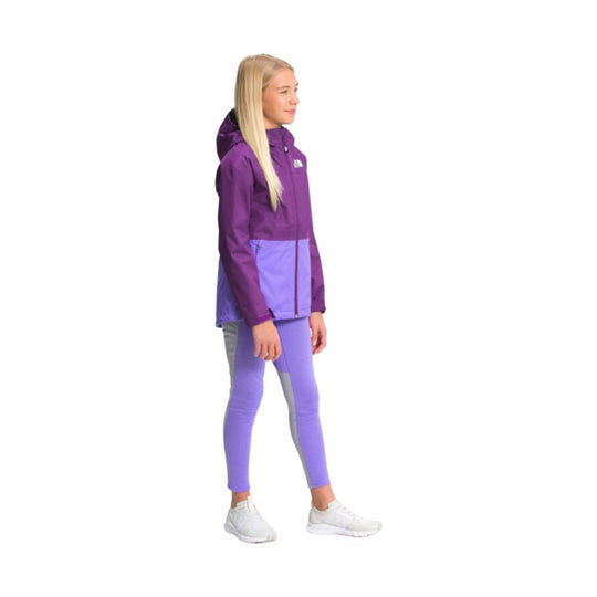 Girl wearing a purple hooded rain jacket with matching leggings and white sneakers, shown in side profile