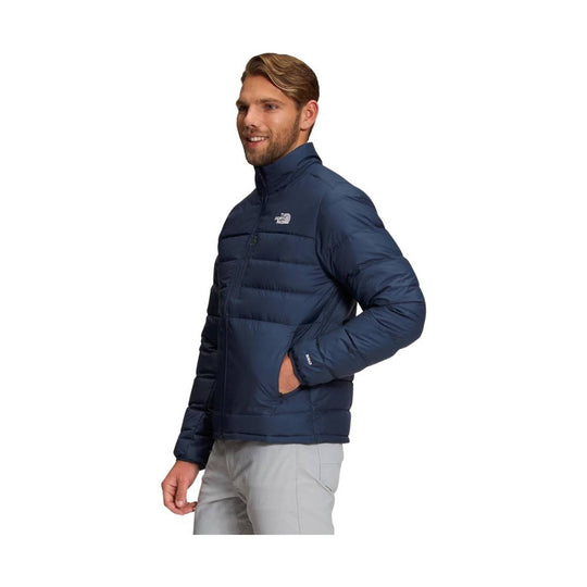 Navy quilted puffer jacket with front zipper, chest logo, and hand pockets