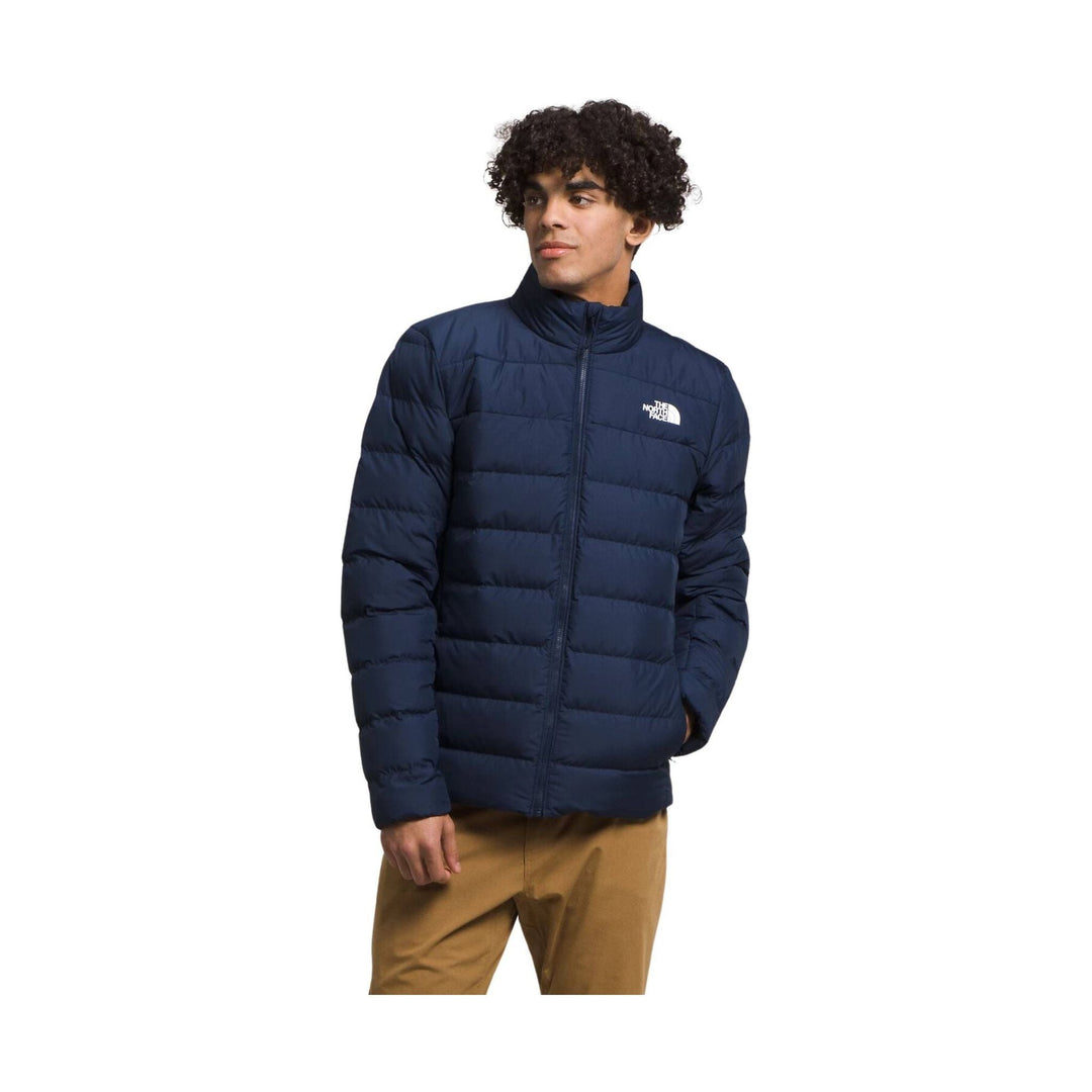 Navy quilted puffer jacket with a stand collar and front zipper, worn by a model