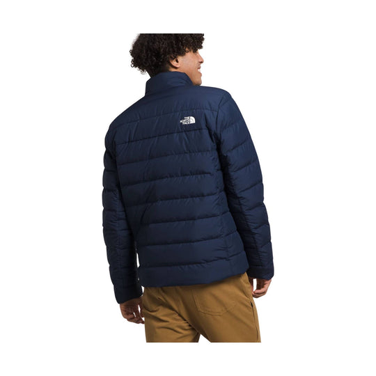 Dark navy quilted puffer jacket shown from the back with a stand collar and small white logo on the upper back
