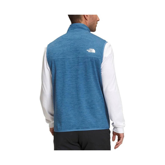 Blue heather men’s fleece vest with a white logo on the upper back, shown from the back over a white long-sleeve shirt