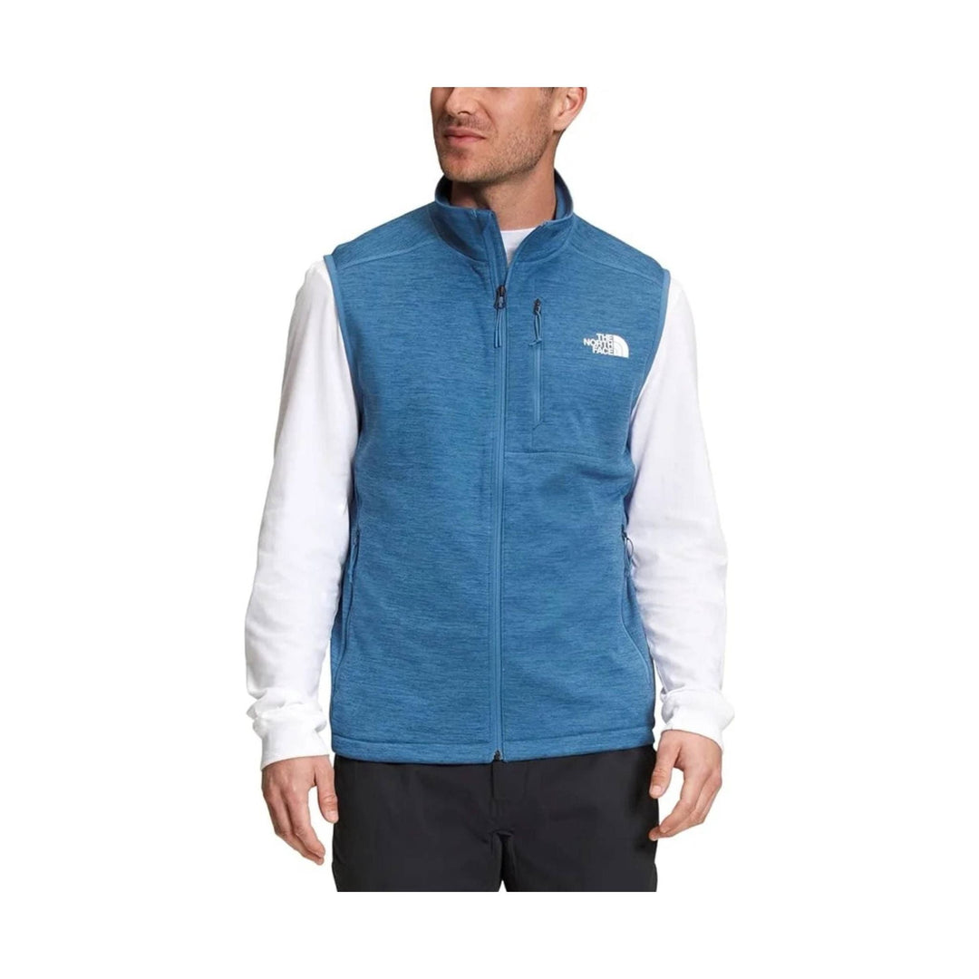 Blue zip-up fleece vest with a stand collar and zip chest pocket over a white long-sleeve shirt