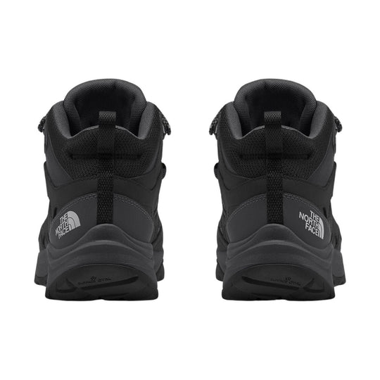 Black mid-height hiking boots shown from the back with padded collars and branded heel logos