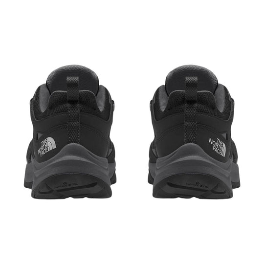 Black low-top hiking shoes shown from the back with knit collars and visible The North Face logos