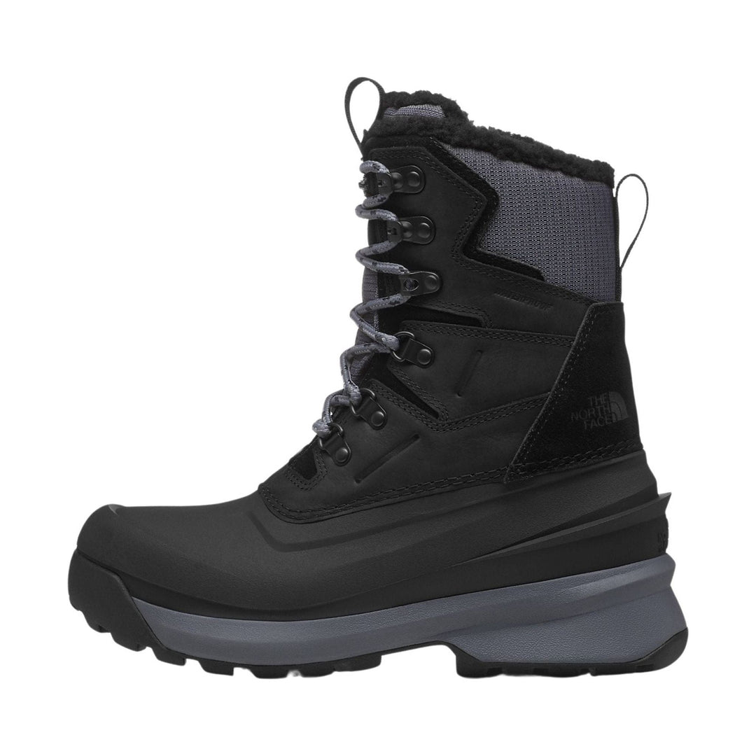 Black high-top winter boot with gray lace-up front, thick treaded sole, and fur lining