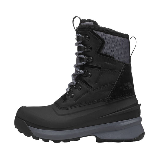 Black high-top winter boot with gray lace-up front, thick treaded sole, and fur lining