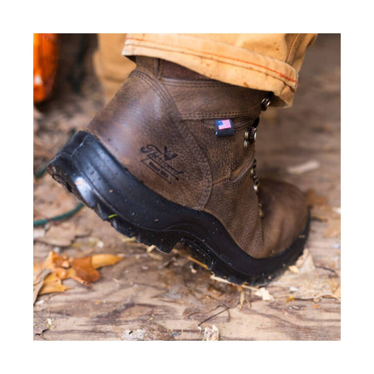 Brown waterproof work boot with black lug sole, shown from the side on a muddy surface