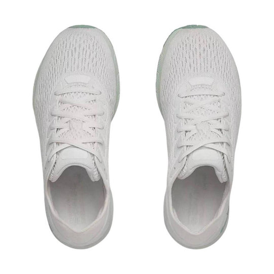 White knit athletic sneakers shown from above, with white laces and light green accents at the toes