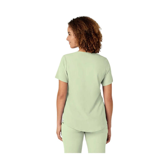 Mint green scrub top shown from the back on a model
