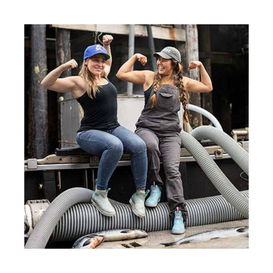 Light blue ankle deck boots worn by two women seated on industrial equipment