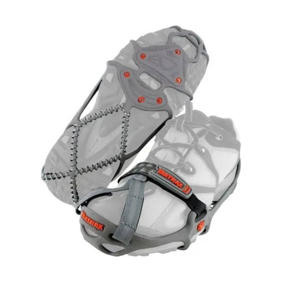 Grey slip-on traction cleat with coil spikes, orange accents, and YAKTRAX label